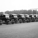 A black and white photo of a line of Model T Ford cars
